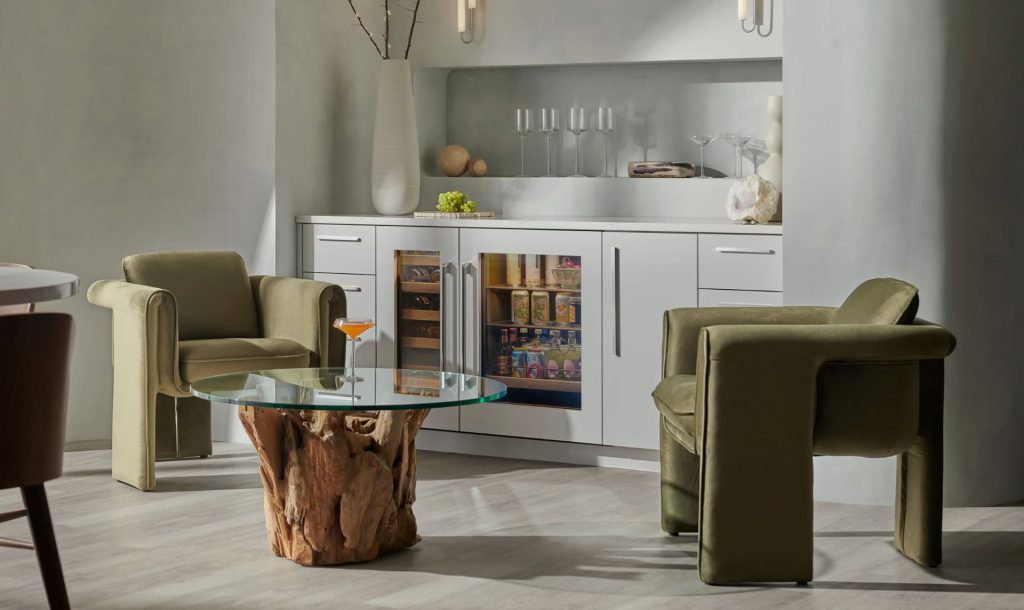 Beverage cooler repair on a built-in glass-front unit installed beside a wine column in an elegant lounge with velvet armchairs.