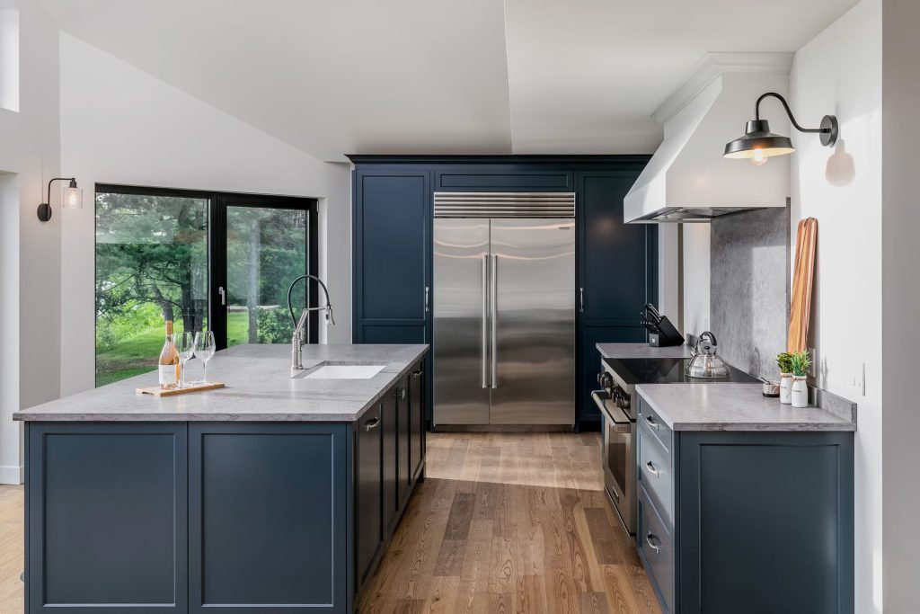 Side-by-side refrigerator repair on a stainless Sub-Zero unit built into navy cabinetry in a luxury Orange County kitchen.