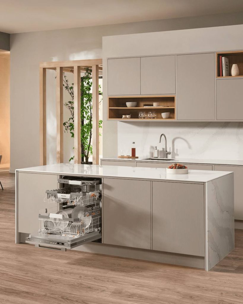 Miele built-in dishwasher repair on a fully integrated panel-ready unit opened inside a kitchen island in a luxury Orange County home.