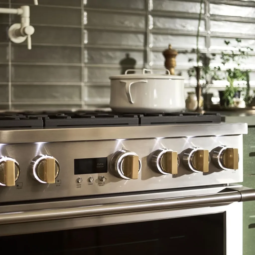 Monogram gas cooktop with brass knobs and a pot